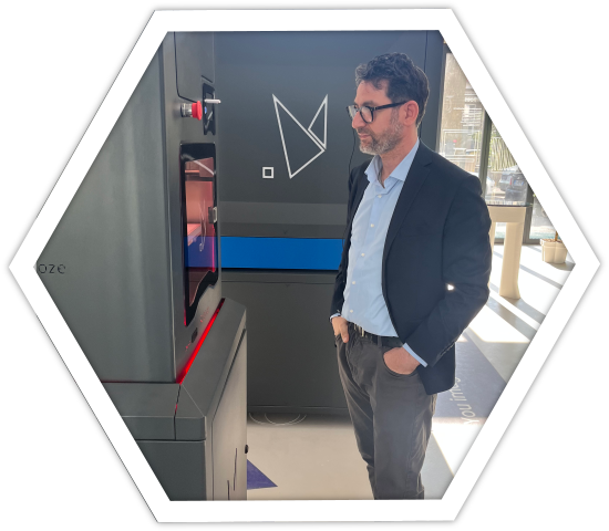 Marco Zullo mentre osserva una stampante 3d industriale